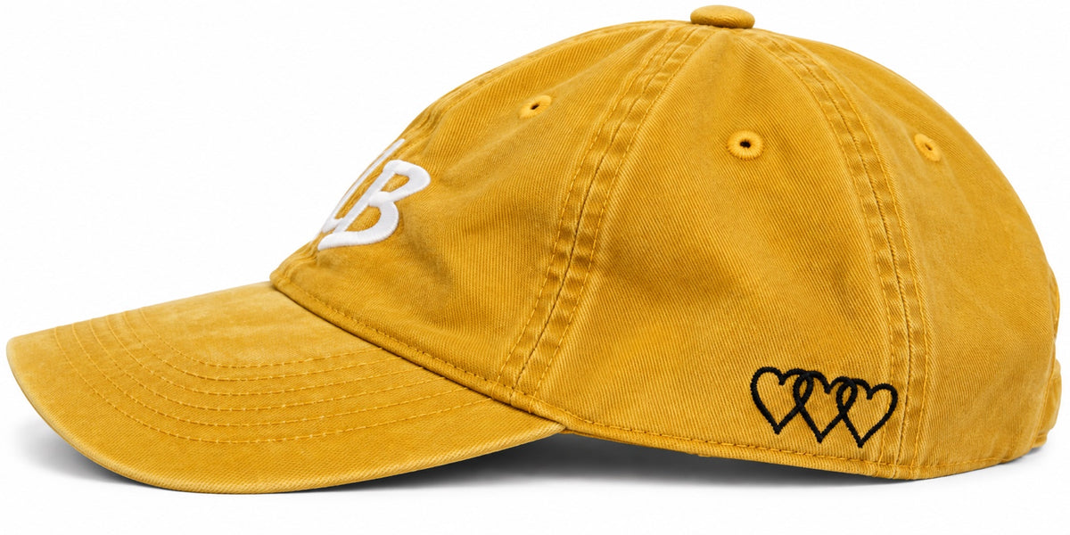 Washed mustard dad hat with three black signature hearts embroidered on side