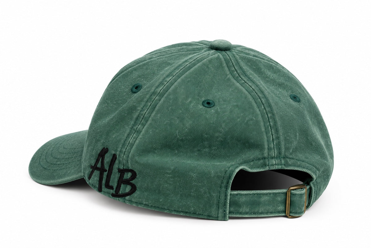Washed green dad hat showing ALB side embroidery and adjustable buckle strap